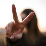 person making a peace sign