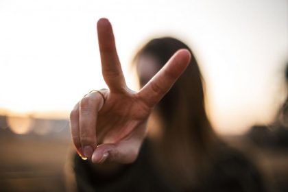 person making a peace sign